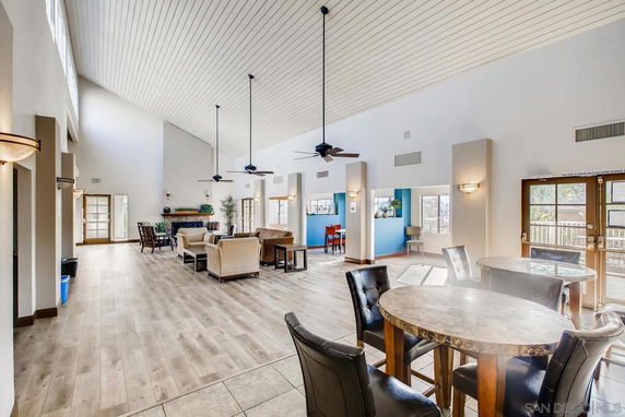Spacious indoor seating area with high ceiling, tables, and chairs for recreation.