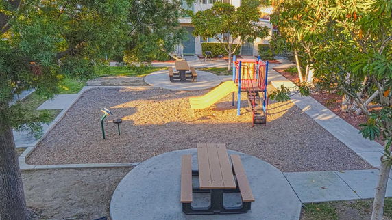 Outdoor playground area with a slide and picnic tables.