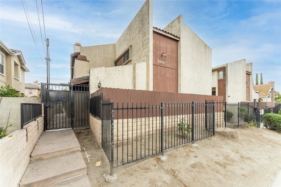 Front view of a multi-story house with a gated entrance