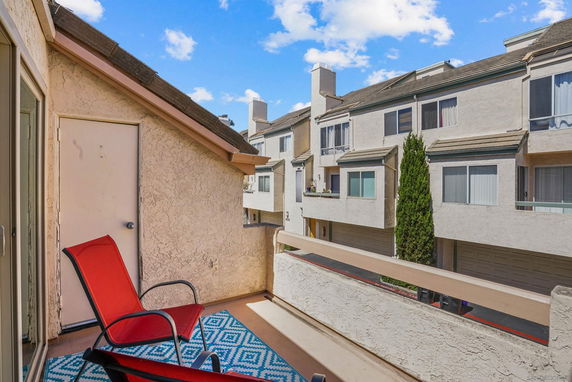 View from a balcony overlooking a residential building with multiple stories and garage doors.