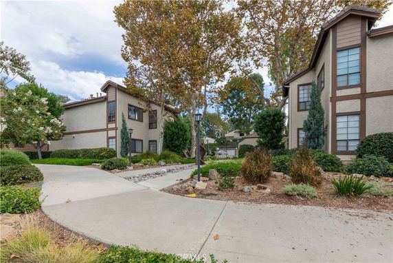 Front view of a two-story residential building with a walkway and landscaping.