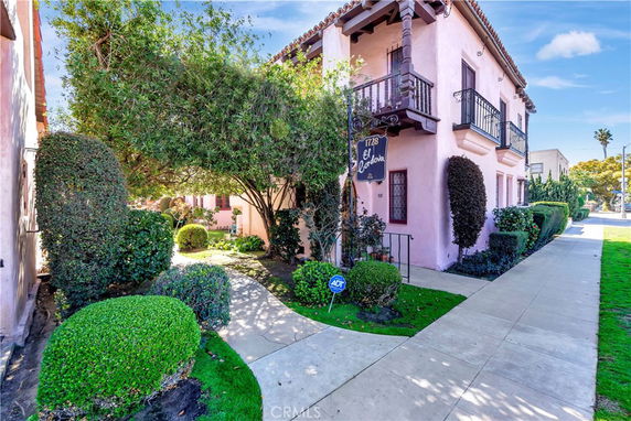 Front view of a two-story building with balconies and a garden path.