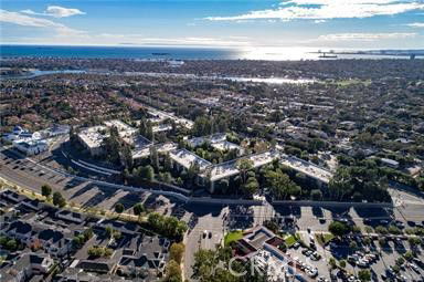 Wide-angle view of a residential area with numerous houses and the coastline in the distance.