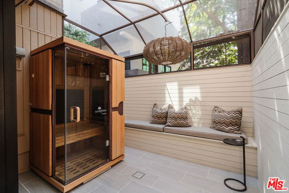 Indoor area with a wooden sauna and a cushioned bench.