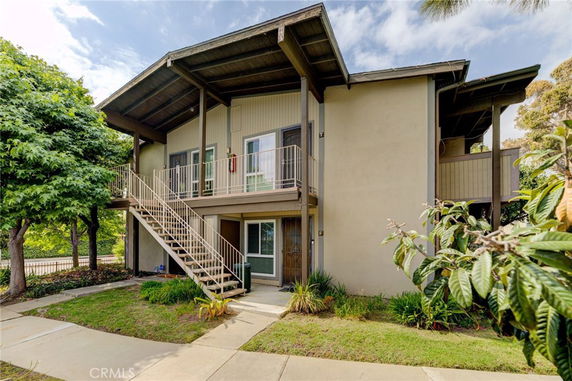 Front view of a two-story building with an external staircase.