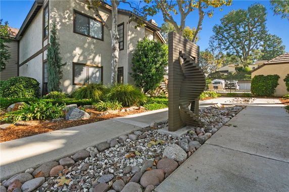 Front view of a two-story house with a modern exterior sculpture.