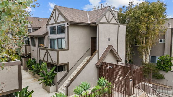 Front view of a multi-story townhouse with a staircase entrance and decorative wood trim.