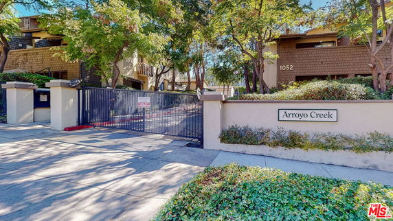 Front view of a gated residential complex with the name Arroyo Creek visible on a sign.