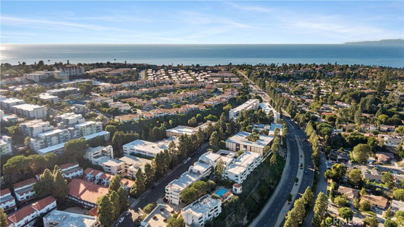Aerial view of a coastal residential area with apartments and houses overlooking the ocean.