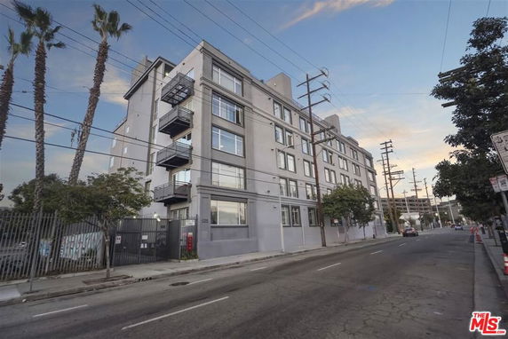 Front view of a multi-story apartment building on a street.