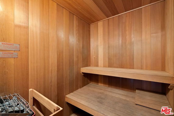 Interior view of a wooden sauna room with benches and a heater.