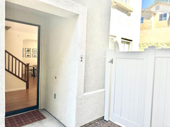 Entryway of a house with a white fence.
