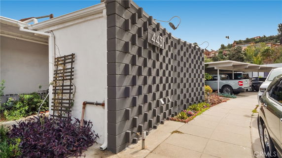 Front view of a building with a patterned wall and a carport.