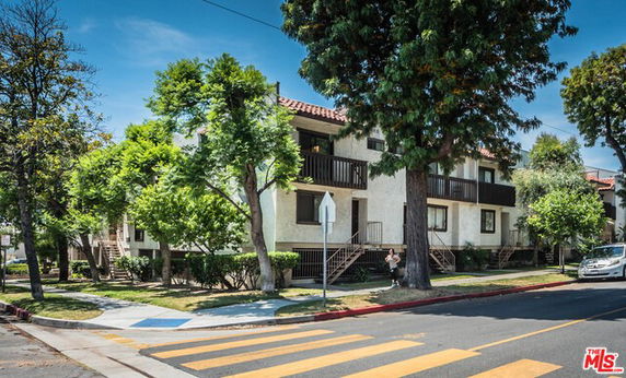 Front view of a two-story building with balconies and a red-tiled roof.