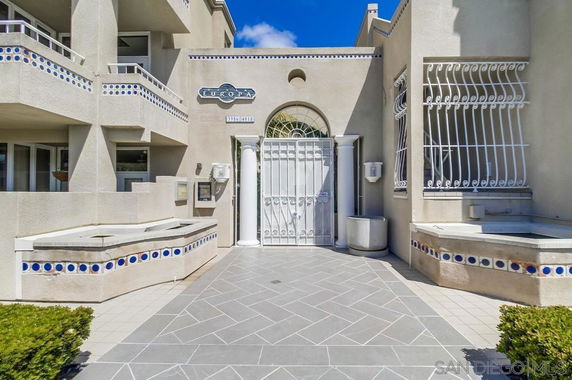 Front view of a multi-story building with decorative tiles and gated entrance.