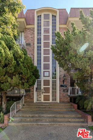 Front view of a multi-story building with a central entrance and brick facade.
