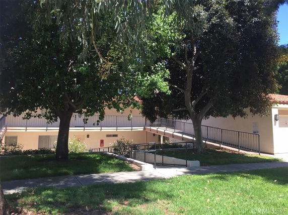 View of a building with trees and a ramp leading to the entrance.