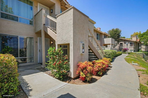 Front view of a two-story apartment building with stairs leading to the upper level.