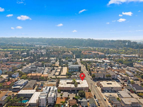 Aerial view of a residential area with multiple buildings and houses, showing a wide landscape of the surrounding neighborhood.