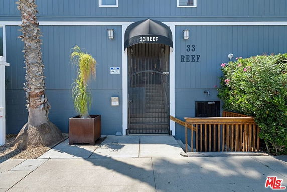 Entrance view of a building with a metal gate and an awning labeled '33 Reef'.