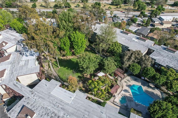 Panoramic view of apartment complex with pool and trees.