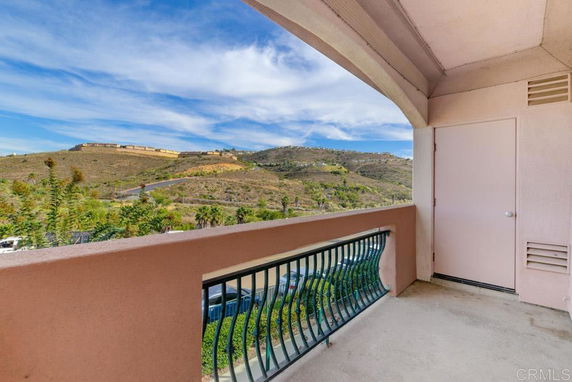 View from a balcony showing hills and a clear sky.