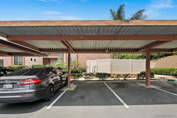 Covered outdoor parking area with parked cars.
