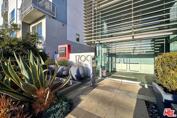 Front view of a modern building with glass entrance and architectural details.