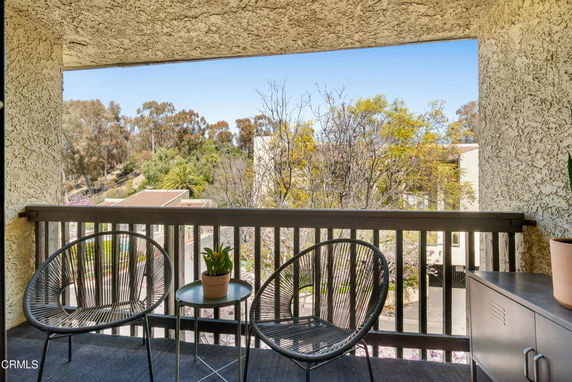View from a balcony overlooking surrounding trees and buildings.