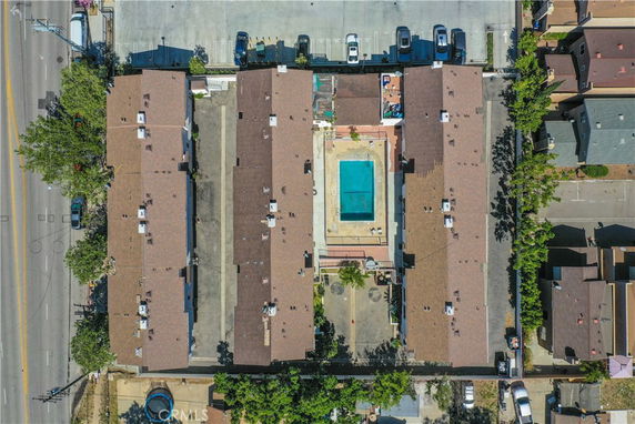 Aerial view of a residential complex with a central swimming pool and parking area.