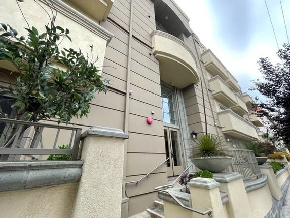 Front view of a multi-story building with columns and balconies.