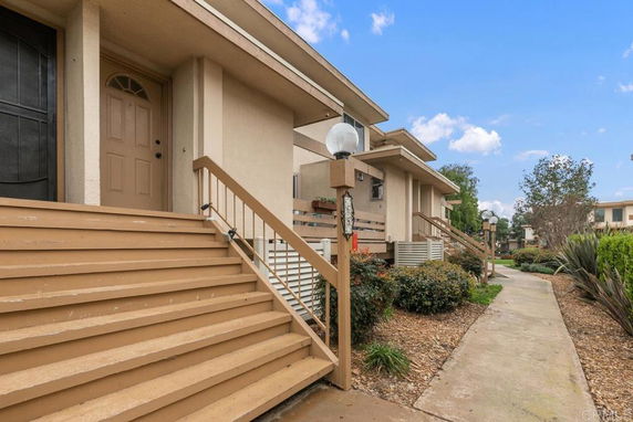 Front view of a residential building with a staircase leading to the entrance.