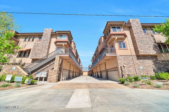 Front view of a multi-story building complex with stone facade and multiple garage doors.