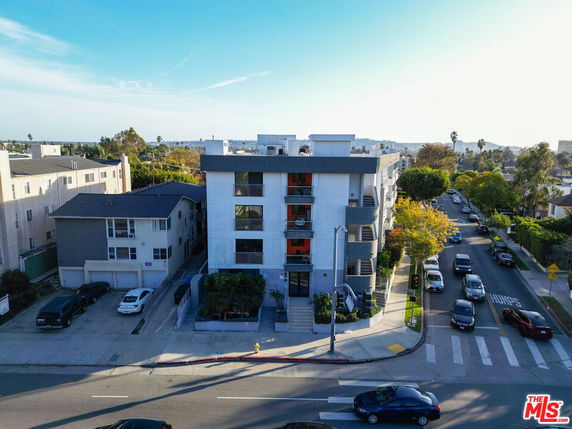 Front view of a multi-story apartment building on a street corner.