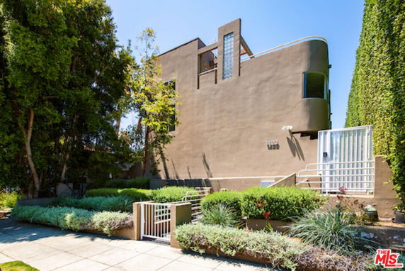 Front view of a modern multi-story house with unique architectural design.