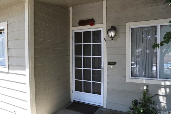 Front view of a house with a screen door and window.