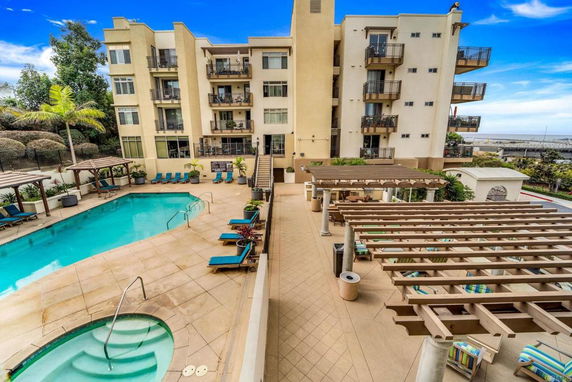 Outdoor view of an apartment building featuring a swimming pool and leisure area.