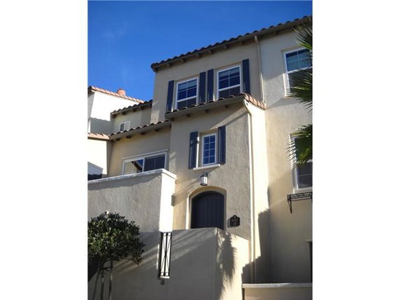 Front view of a multi-story house with multiple windows and a small balcony.