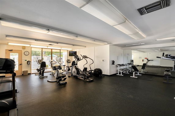 Indoor gym area with exercise equipment and mirrors.