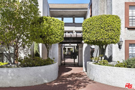Front view of a multi-story building with a gated entrance.