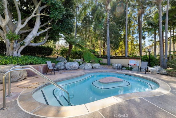Outdoor pool area with surrounding trees and lounge chairs