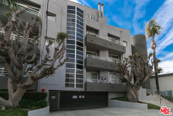 Front view of a multi-story building with balconies and modern architecture.