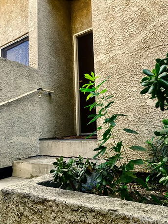Entrance of a building with textured walls and a small stairway.