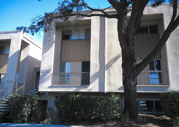 Front view of a multi-story residential building with balconies.