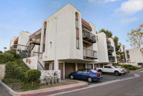 Front view of a multi-story residential building with balconies and staircases.