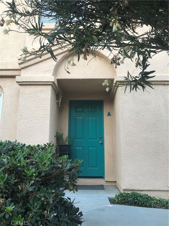 Front view of a house with a teal door and archway.