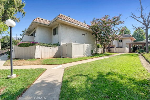 Front view of a residential building with a tiled roof and fenced yard.