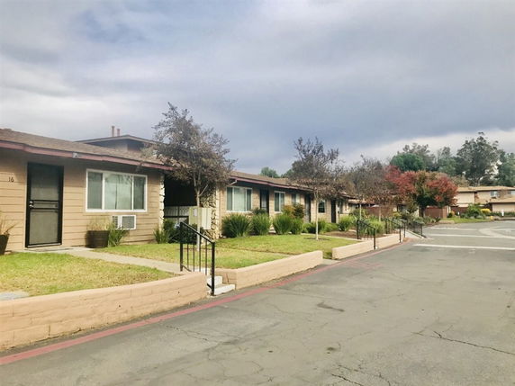 Front view of a row of single-story houses with small lawns.