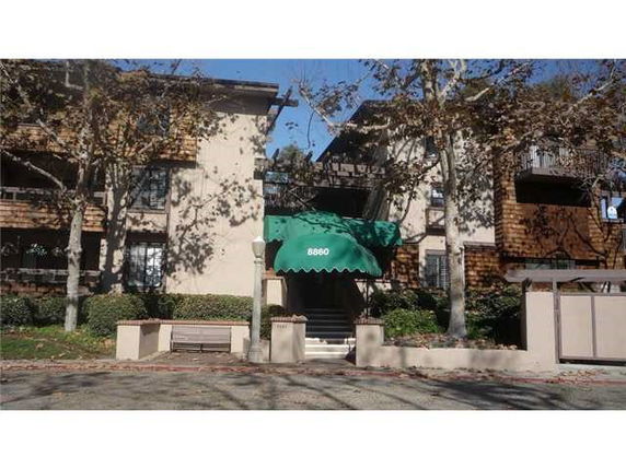 Front view of a multi-story residential building with a green awning at the entrance.