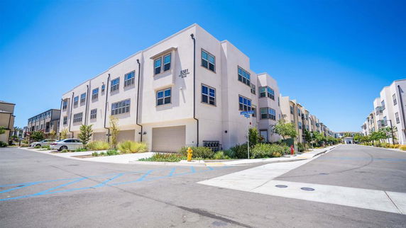 Front view of a multi-story apartment building with garages.
